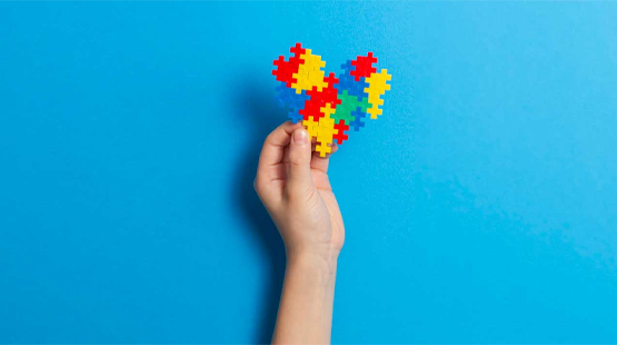 Child's hand holding up puzzle heart
