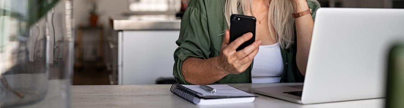 woman-with-phone-and-laptop-1300x350