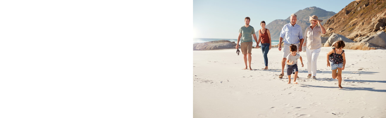 Three generation family walking together on a sunny beach