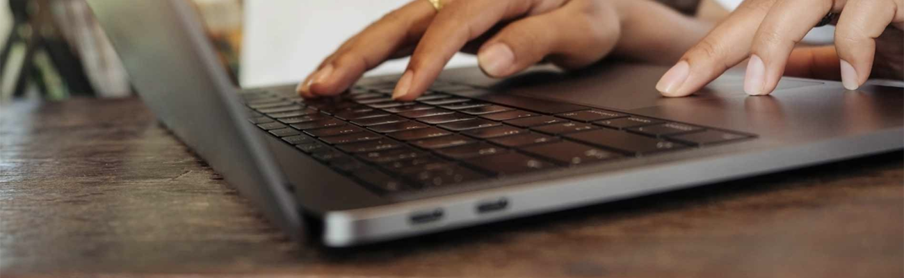 Hands typing on laptop computer keyboard