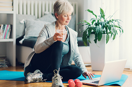 woman looking at workout with weights on floor